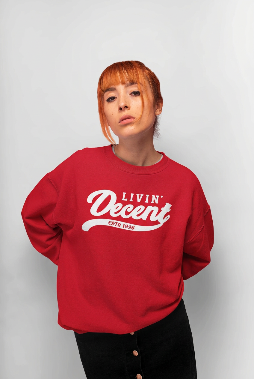 Model wearing a red Livin Decent crewneck with a white logo